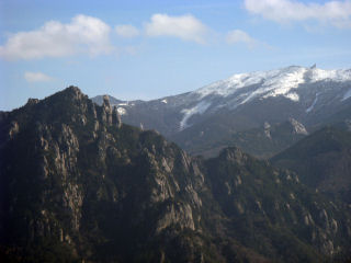 手前の岩山は瑞牆山（ミズガキヤマ）、雪をかぶっているのは金峰山（キンプサン）